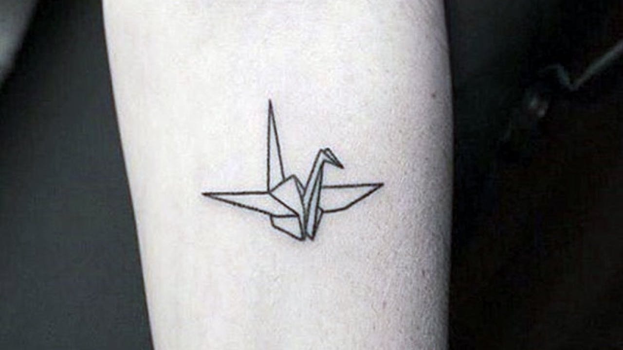 Figura de origami tatuada en antebrazo.