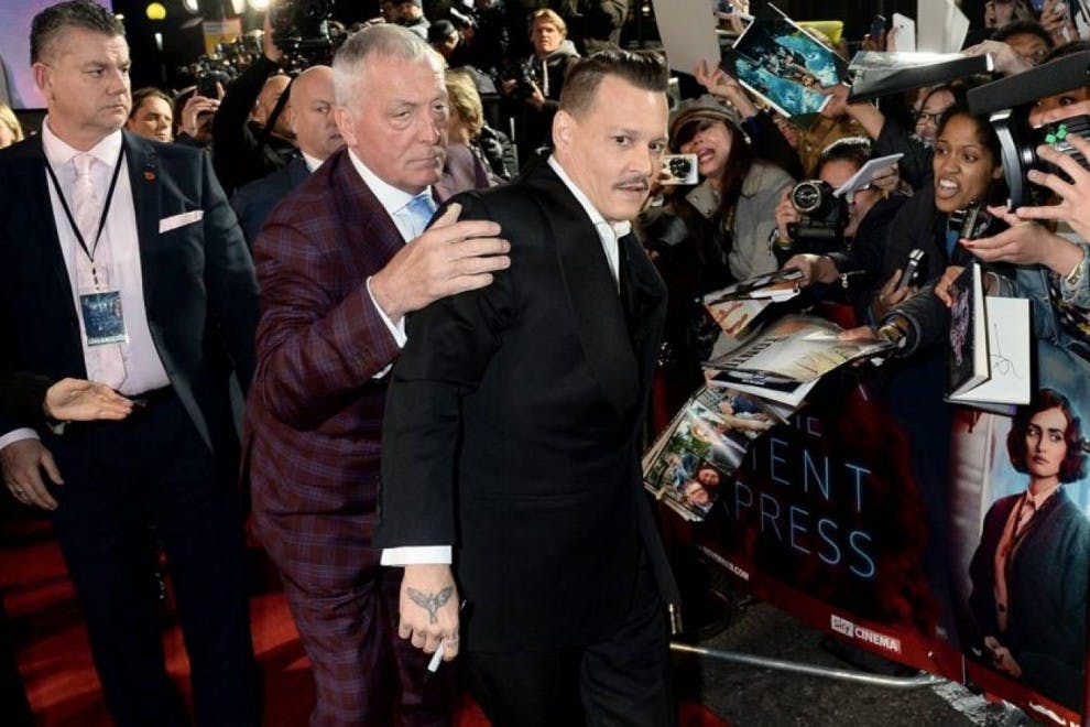 Johnny Depp es sujetado por sus guardaespaldas en el estreno de su última película.